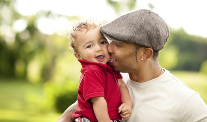 Father kissing his toddler son on the cheek