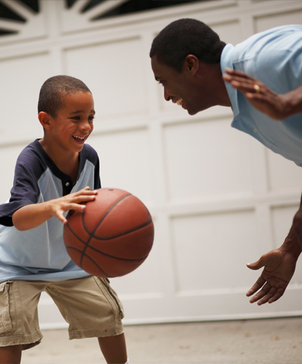 Father and young son playing basketball